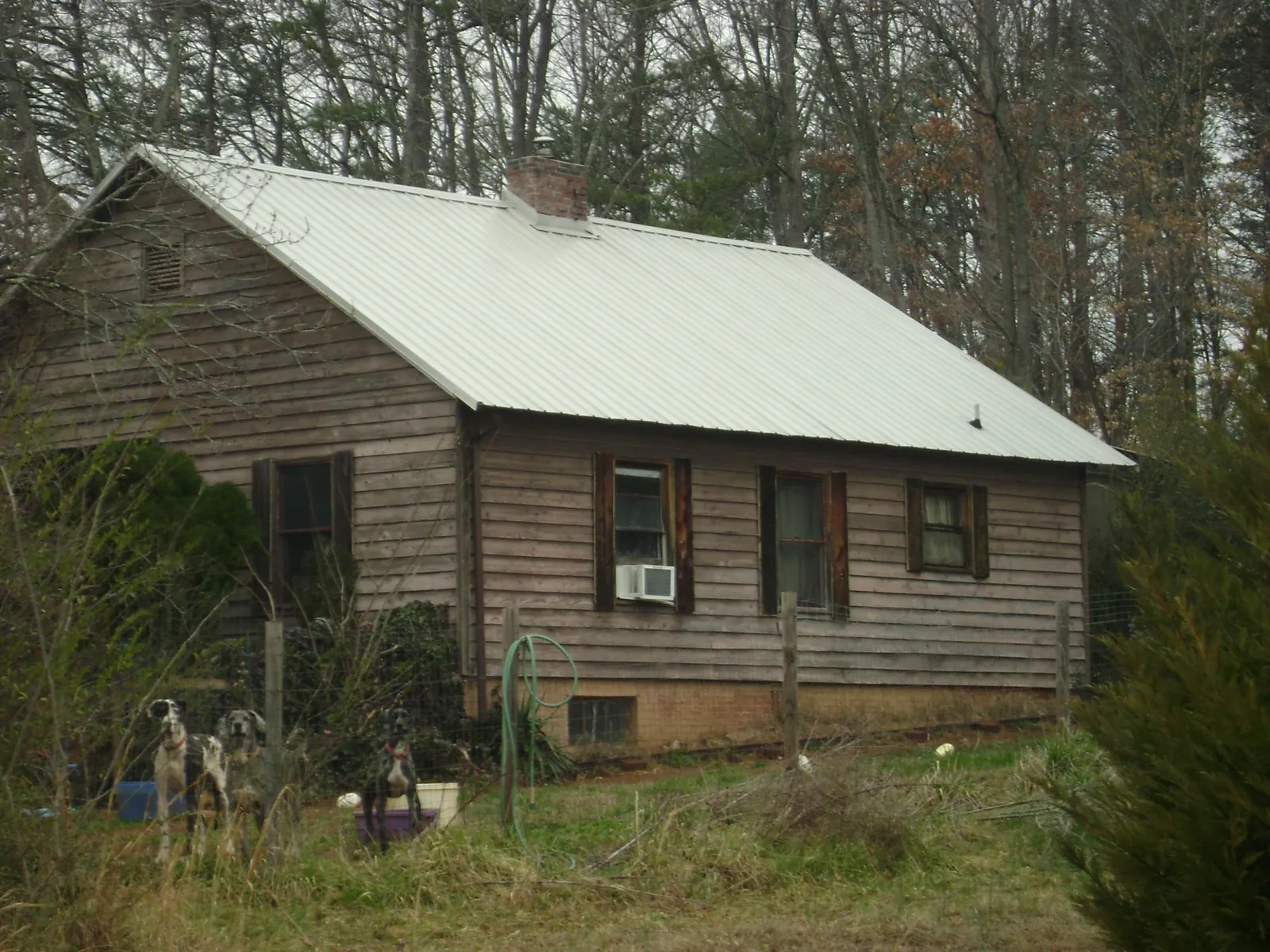 White metal roof on an old wood sided farmhouse, from a Metal Roof Installation job in Martinsville